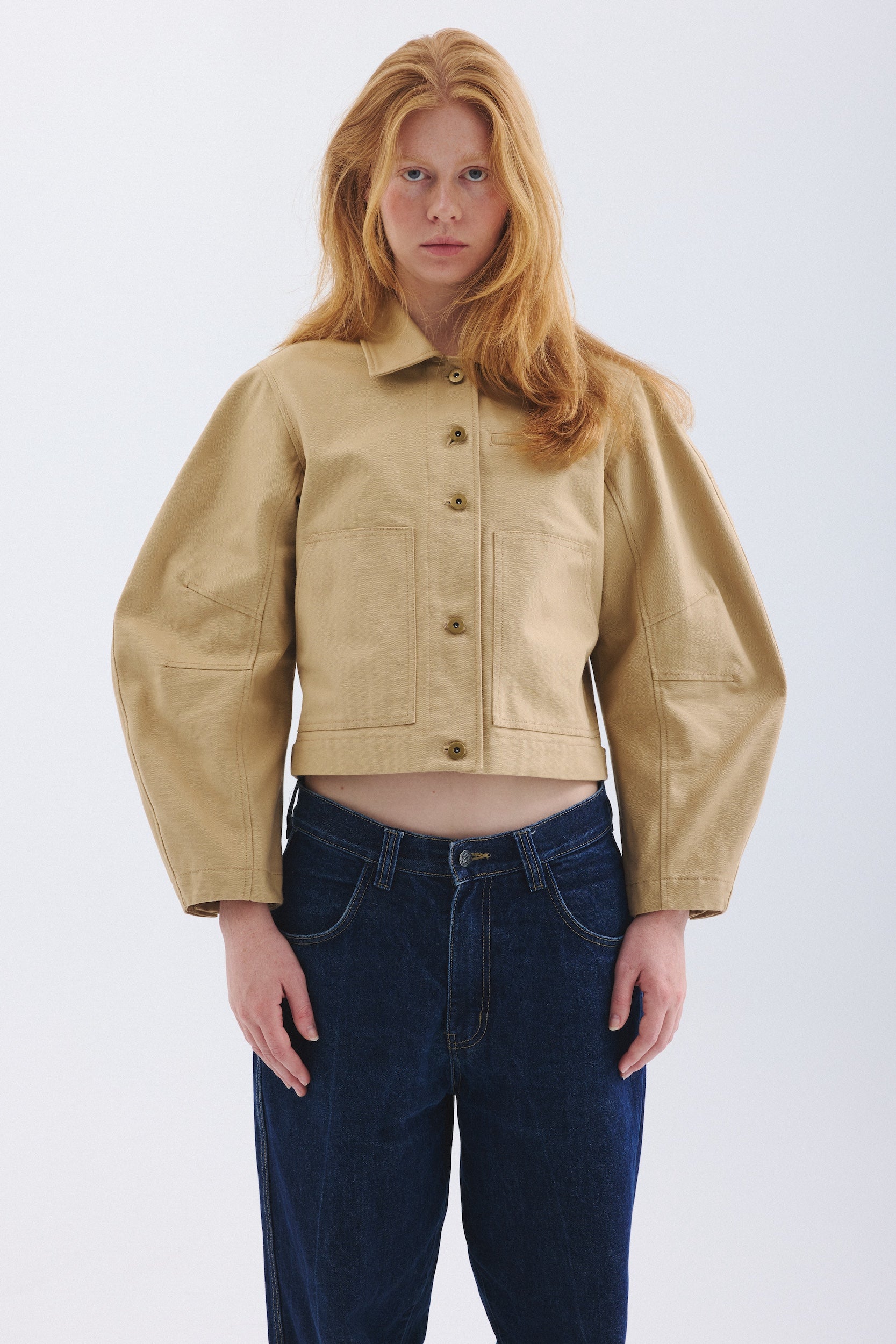 Front view of Model wearing sand colored Palmetto jacket with jeans